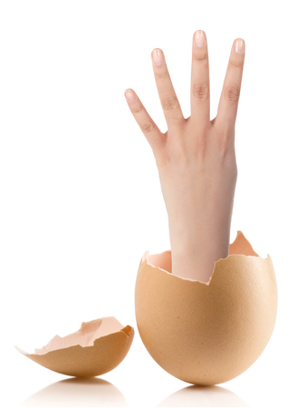 Hand with broken egg isolated on white backround.Image of female hand showing four fingers on a white backgroundの写真素材