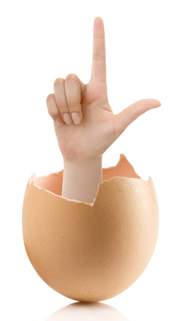 Hand with broken egg isolated on white backround. Woman index finger isolated on white backgroundの写真素材