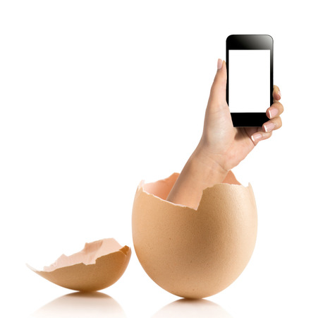 Hand with broken egg isolated on white backround. Hand of young man holding smart phone white screen isolated on white background with clipping pathの写真素材