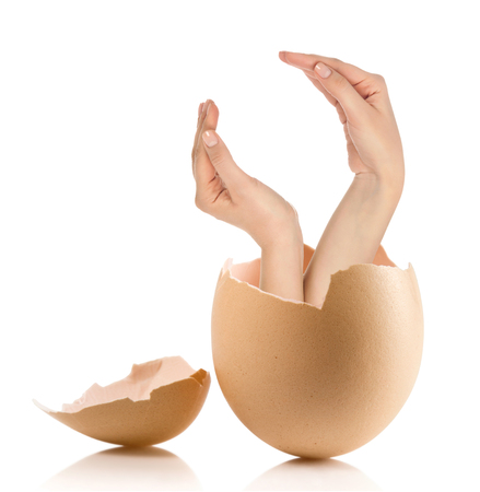 Hand with broken egg isolated on white backroundの写真素材