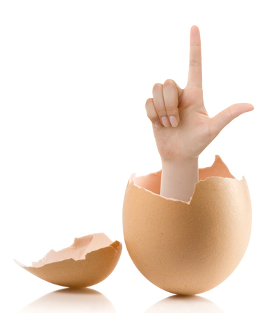 Hand with broken egg isolated on white backround. Woman index finger isolated on white backgroundの写真素材