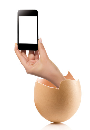 Hand with broken egg isolated on white backround. Hand of young man holding smart phone white screen isolated on white background with clipping pathの写真素材