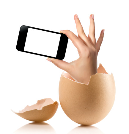 Hand with broken egg isolated on white backround. Hand of young man holding smart phone white screen isolated on white background with clipping pathの写真素材