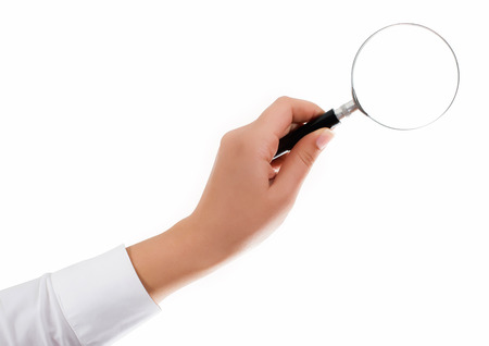 Female hand holding the magnifying glass isolated on white backgroundの写真素材