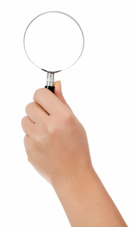 Female hand holding the magnifying glass isolated on white backgroundの写真素材