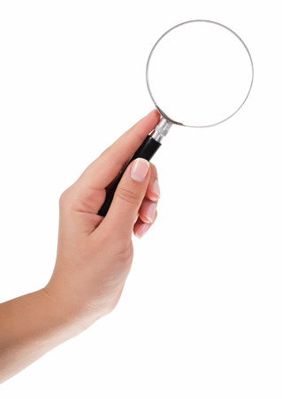 Female hand holding the magnifying glass isolated on white backgroundの写真素材