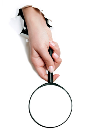 Female hand holding the magnifying glass isolated on white backgroundの写真素材