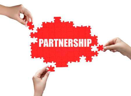 hand holding a piece of white success puzzleの写真素材