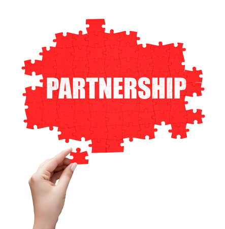 hand holding a piece of white success puzzleの写真素材