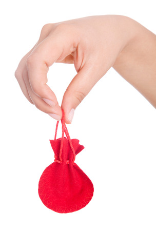 Hand of business woman holds bag full of money. Isolated on white background.の写真素材