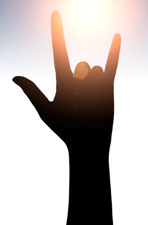 Raised hands catching sun on sunset sky. Concept of spirituality, wellbeing, positive energy etc.の写真素材