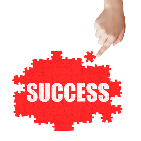 hand holding a piece of white success puzzleの写真素材