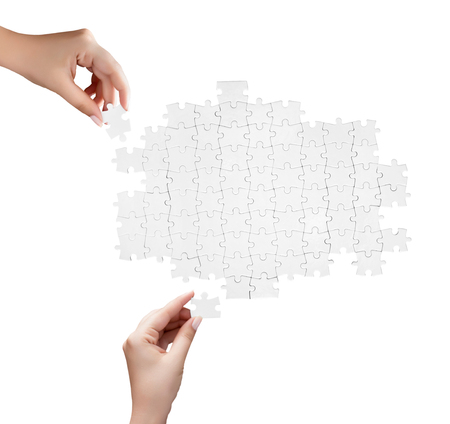 hand holding a piece of white uncompleted puzzleの写真素材