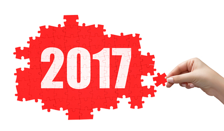hand holding a piece of white 2017 puzzle