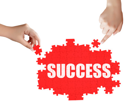 hand holding a piece of white success puzzleの写真素材
