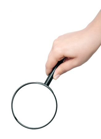 Female hand holding the magnifying glass isolated on white backgroundの写真素材