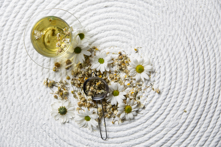 Food background with different black and green dry tea, rose buds cup of hot tea and iron teapot over dark wooden background. Tea drinking concept. Top view. Square imageの写真素材