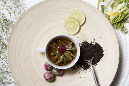 Food background with different black and green dry tea, rose buds cup of hot tea and iron teapot over dark wooden background. Tea drinking concept. Top view. Square imageの写真素材