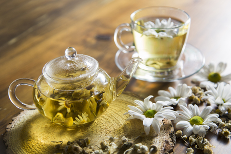 Food background with different black and green dry tea, rose buds cup of hot tea and iron teapot over dark wooden background. Tea drinking concept. Top view. Square imageの写真素材