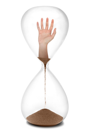 Hand is reaching in hourglassの写真素材