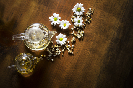 Food background with different black and green dry tea, rose buds cup of hot tea and iron teapot over dark wooden background. Tea drinking concept. Top view. Square imageの写真素材
