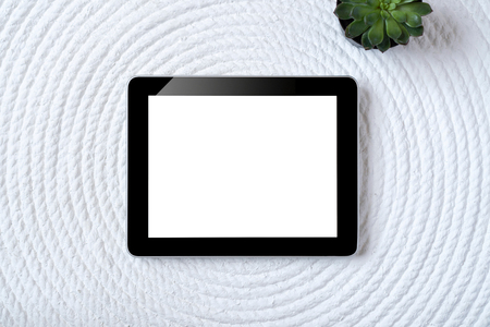 Office table with tablet, computer, coffee cup and flower. View from above with copy spaceの写真素材