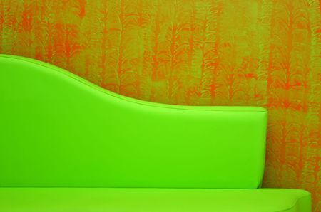 green sofa back-rest over a stylish red wall-paperの写真素材