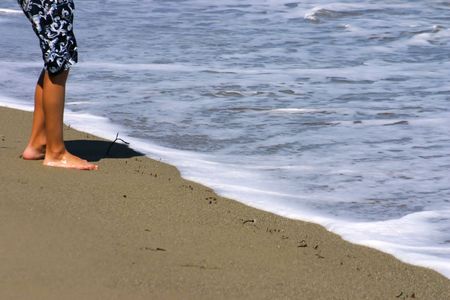 Young boy standing at the beach. Summer and holiday conceptの写真素材