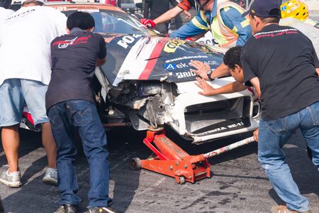 staff team pushing wrecked racing carのeditorial素材