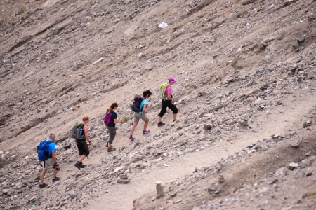 Group of travellers trekking on rock mountainの写真素材