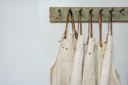 white apron clothes hanging on the wallの写真素材