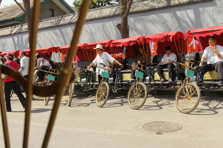 BEIJING - APRIL 14 : Hutong tricycle rider waiting for tourist ,April 14, 2012 Beijing, Chinaのeditorial素材