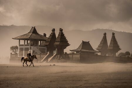 vintage color of horse rider front of Hindu temple Pura Luhur Poten, Bromo
