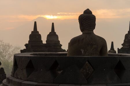 morning sunrise silhouette buddha sculpture in open stupa at Borobudur, Indonesiaの写真素材
