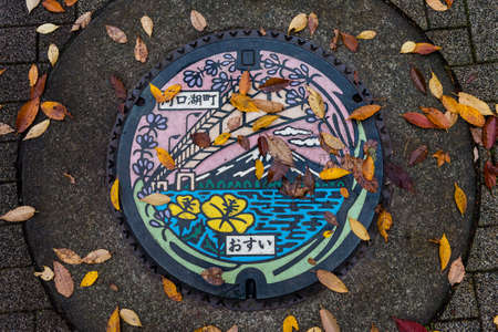 Metal sewer manhole of Kawaguchiko lake art color street in autumnの写真素材