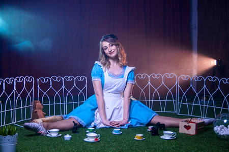 Lovely happy Alice sits on a glade in Wonderlandの写真素材