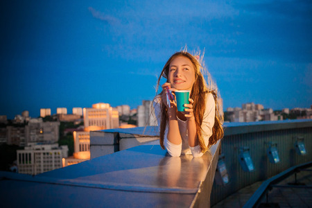 Birthday girl in braces against the background of the night sky and the cityの写真素材