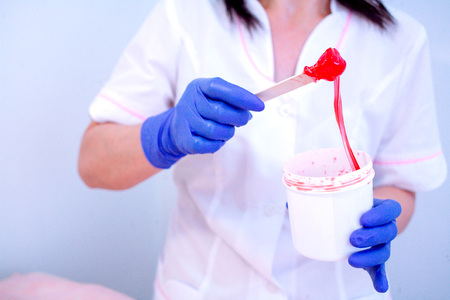 Woman beautician in gloves and with paste for shugaringの写真素材