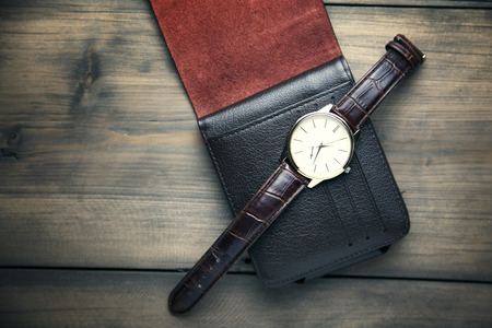 elegant watch and wallet on wooden tableの写真素材