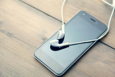 phone and headphones on wooden tableの写真素材