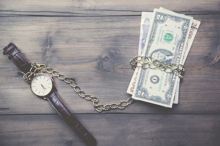 Pocket watch and cash money on woodの写真素材