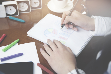 woman writing  pencil on notebook on wooden tableの写真素材