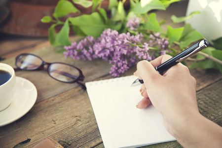 woman hand pen and coffee on wooden tableの写真素材