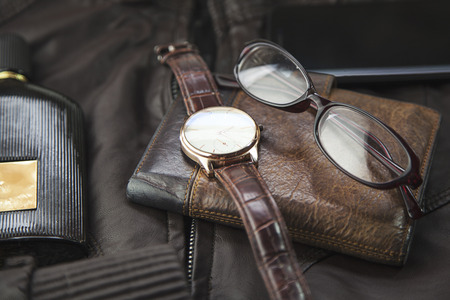 watches,glasses, wallet, perfume  and phone on   leather