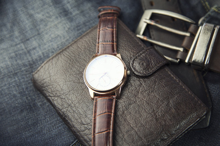 watch,wallet and jeans on table