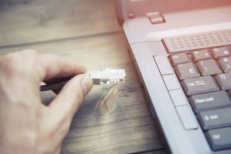 man hand power cord into the computerの写真素材