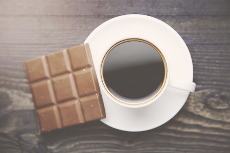 Cup of coffee with chocolate on wooden tableの写真素材