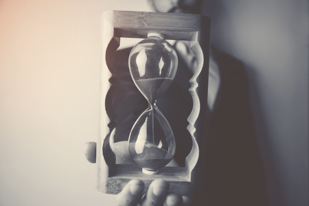 Business man holding hourglass, time conceptの写真素材