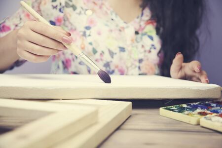 women hand with brush drawing on canvasの写真素材