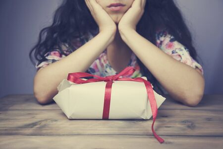 Woman's hands wrapping present on wooden table